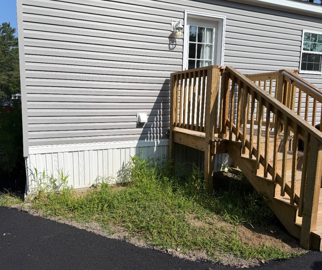 Front door area with wooden deck stairs and bare dirt — the Little Garden before it began